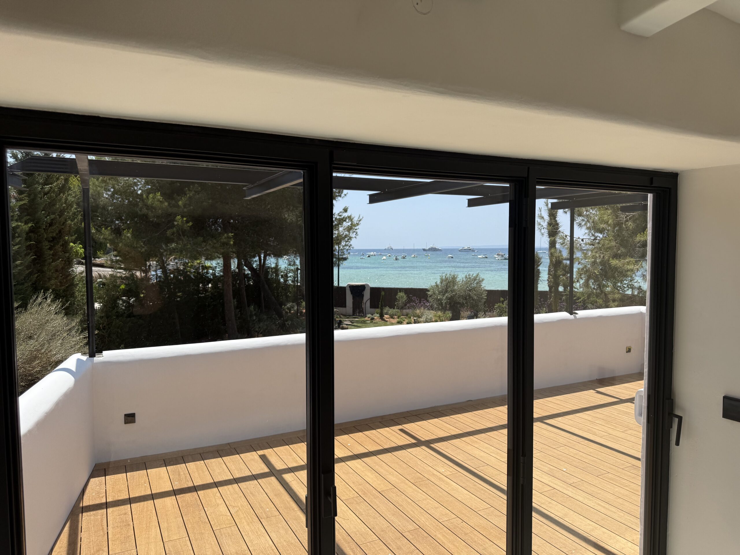 Interior de vivienda abierto a una terraza con vistas al mar